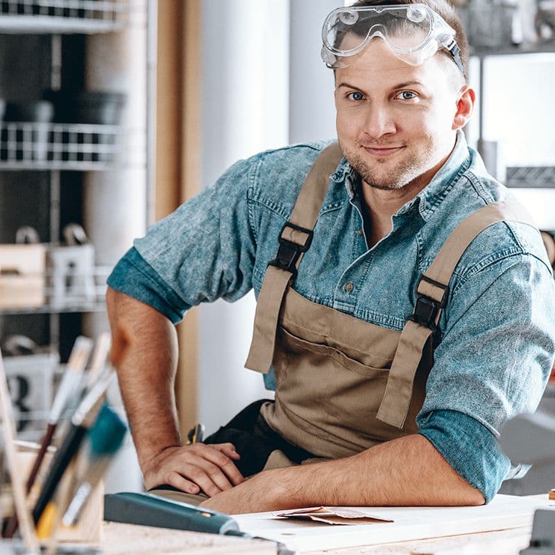 Handwerker in einer Werkstatt als Beispiel für den Einsatz ergonomischer Arbeitsstühle